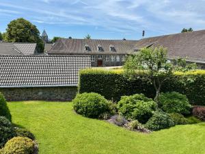 a yard with a hedge and a garden with a yard sidx sidx at Eifelstube - Cozy 130 qm apartment with big sun terrace in Monschau