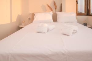 a white bed with towels on top of it at The Pelion Sunrise in Agios Ioannis Pelio