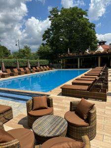 a swimming pool with lounge chairs and a swimming pool at ATOS Srebrno jezero - Villa and Restaurant in Veliko Gradište