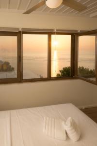 a bedroom with a bed with a view of the ocean at The Pelion Sunrise in Agios Ioannis Pelio