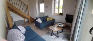 a living room with a blue couch and a table at Maison cosy au calme à 15 min du Pal - l'Ecole Buissonnière in Saligny-sur-Roudon