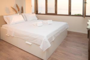 a white bed with white sheets and towels on it at The Pelion Sunrise in Agios Ioannis Pelio