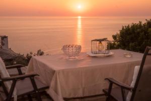 a table with a bowl on it with the sunset at The Pelion Sunrise in Agios Ioannis Pelio