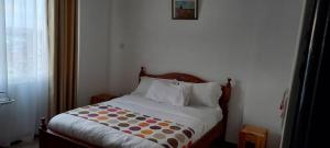a bed with a polka dot blanket on it in a bedroom at One Bedroom Cottages at Elmadel in Machakos