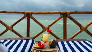 ein Balkon mit zwei Stühlen und einem Tisch mit einem Getränk in der Unterkunft Moya Beach Hotel in Marumbi
