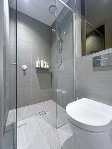 a bathroom with a toilet and a glass shower at 2-Bedroom Apartment in Melbourne CBD with Balcony, Pool & Gym Access in Melbourne
