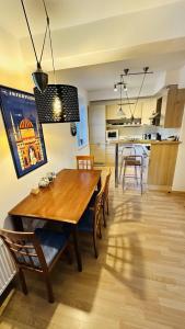 a dining room and kitchen with a wooden table and chairs at Apartmán Špindl 101čka Dalibor II in Špindlerův Mlýn