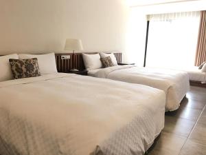 Voodi või voodid majutusasutuse Palm Tree Hotel Kenting toas