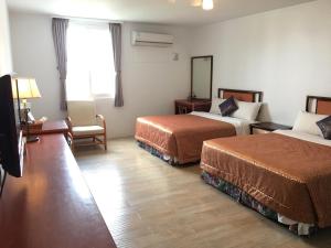 Voodi või voodid majutusasutuse Palm Tree Hotel Kenting toas