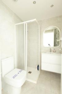 a white bathroom with a toilet and a sink at Soto de la Marina I Parking Privado I Wifi I Playa in Soto de la Marina