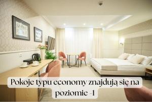 a hotel room with a bed and a table and chairs at Apartamenty Klasztorna 25 in Poznań