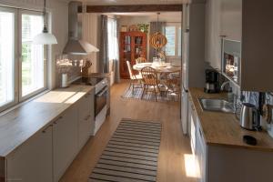 eine Küche mit weißen Schränken und ein Esszimmer in der Unterkunft Nybacka Torp in Raseborg