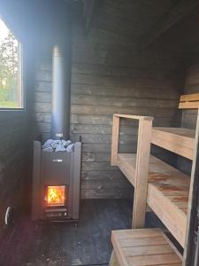 ein Holzofen in einer Hütte mit Treppe in der Unterkunft Nybacka Torp in Raseborg