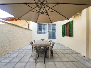 a table and chairs under an umbrella on a patio at Casa Michelangelo in Certaldo
