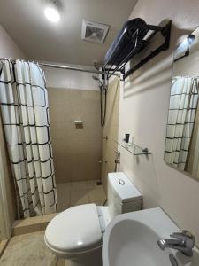 a bathroom with a toilet and a sink and a shower at Stanford Suites 3, staycation near Nuvali, located in Silang in Bayabasan +1 photo