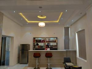 a woman sitting at a bar in a room at Citi Residence - Banana Island Rd, Ikoyi, Lagos in Ikoyi