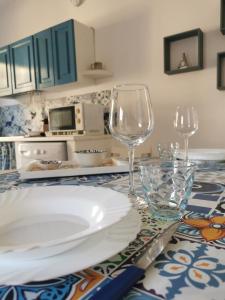 a table with a plate and two wine glasses on it at Casa Pélagos a 50mt dal mare in Nicotera Marina +34 photos