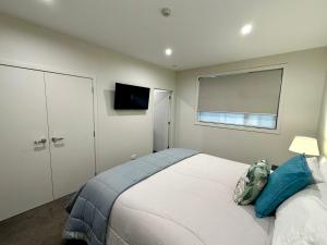 クロムウェルにあるHighlands Oasisの大きな白いベッドと窓のある寝室