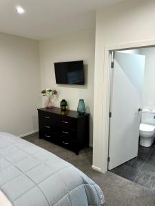 クロムウェルにあるHighlands Oasisのベッドと壁掛けテレビのある寝室