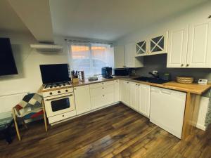 une cuisine avec des armoires blanches et un plancher en bois dans l'établissement Cabana Revnic, à Băişoara 19 autres photos