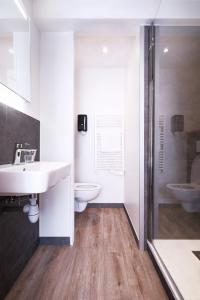 une salle de bains avec lavabo, toilettes et douche dans l'établissement Hôtel le Christiania, à Arêches 17 autres photos