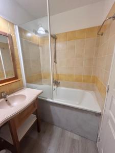a bathroom with a bath tub and a sink at La Maison Tranquille at the Lake 1 Bedroom House in Marciac