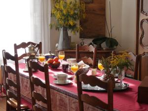 a dining room table with a red table cloth at Le point d'orgue in Pineuilh