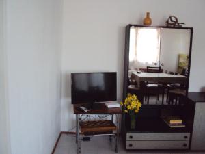 een woonkamer met een tv en een spiegel bij Villa Chervenka in Chernomorets