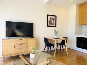 a living room with a tv and a table with chairs at Stunning Modern Self-contained Apartment in Beaumont