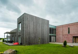 a large metal building with a grass yard at Kuressaare Marina Apartment in Kuressaare
