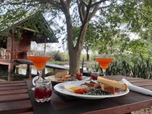 a table with two plates of food and two wine glasses at sanilka rooms and eco estate 