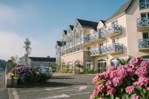 a large building with flowers in front of it at Hotel Aigue Marine in Tréguier