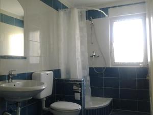 a bathroom with a toilet and a sink and a window at Apartments MiaMaja in Novalja