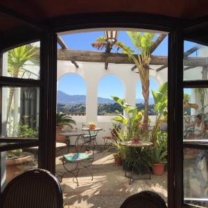 a patio with a view of the mountains through the windows at Hotel Casa Henrietta in Jimena de la Frontera