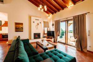 a living room with a green couch and a fireplace at Ostria villa in Chóra