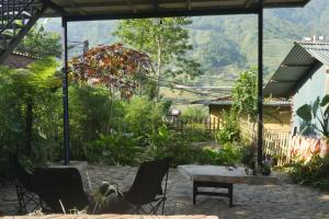 a patio with a table and chairs and a mountain at Nương Homestay in Sa Pa
