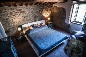 um quarto com uma cama e uma parede de pedra em Morelliana4Rooms em Scansano