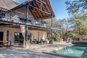 an outdoor patio with a deck and a swimming pool at Kube at Kruger in Marloth Park