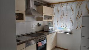 a kitchen with white cabinets and a stove top oven at White Sand Haven Guest House in Ebhausen