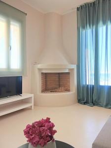 Una sala de estar con chimenea y televisión. en Aktaea, Seaside Residence, 