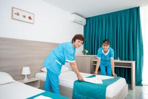 a woman and a girl making a bed in a hospital at Hotel Favorit in Venus +45 photos