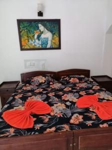 a bedroom with a bed with a floral bedspread and two pillows at Mount Villa in Dehiwala