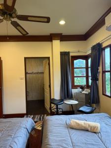 a bedroom with two beds and a room with a table at Sweet home in Bangrak Beach +3 photos
