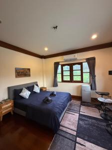 a bedroom with a blue bed and a window at Sweet home in Bangrak Beach