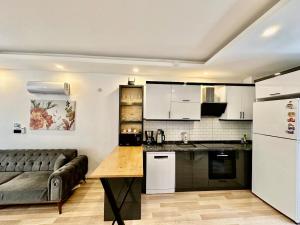 a kitchen with white cabinets and a couch in a room at Villa Maldives, right on sea in center of Fethiye in Fethiye