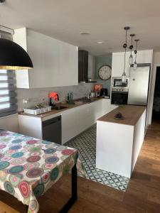 Una cocina con gabinetes blancos y encimera. en Casa Fontain, en Sant Cugat del Vallès 7 fotos más