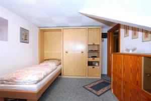 Schlafzimmer mit einem Bett und einem Holzschrank in der Unterkunft Private Apartment in Hannover