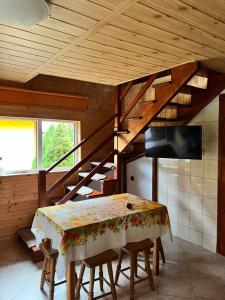 a dining room with a table and a wooden staircase at Gospodarstwo Agroturystyczne na Górce in Myczkowce