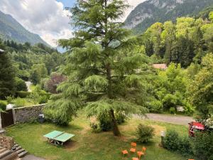 a picnic table and chairs next to a tree at Gîte de charme dans la vallée du Borne au cœur des Alpes in Glières-Val-de-Borne