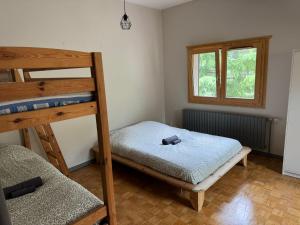 a bedroom with two bunk beds and a window at Gîte de charme dans la vallée du Borne au cœur des Alpes in Glières-Val-de-Borne